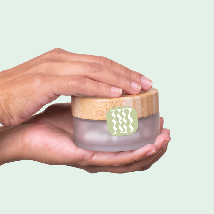 Woman picking up encapsulated facial cleansing powder that is vegan, cruelty free and zero waste