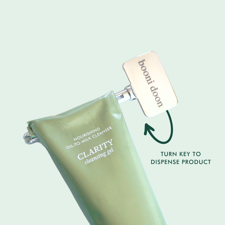 Image of booni doon's COMFORT Tube Key on CLARITY Cleansing Gel's aluminum tube to dispense product