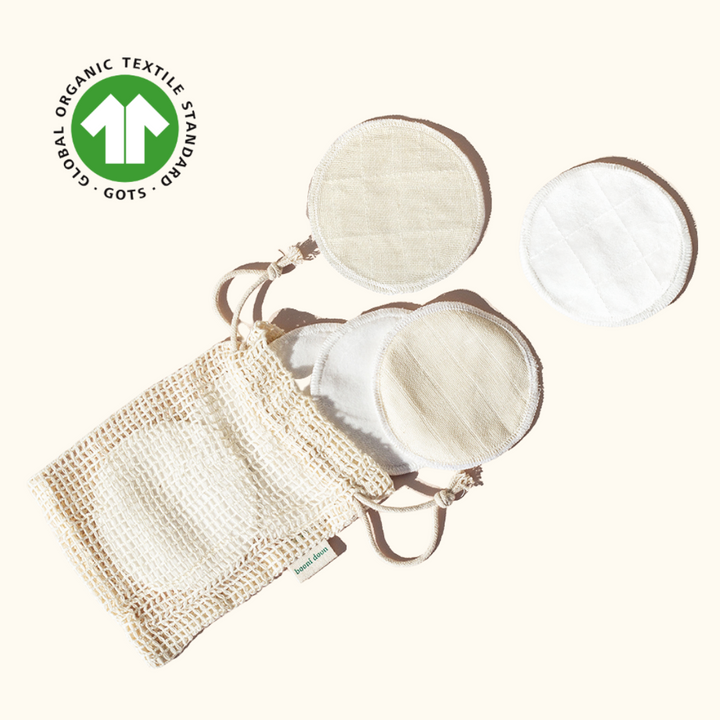 Flat lay image of booni doon's PLUSH reusable facial rounds coming out of a mesh bag with booni doon tag; GOTS certification seal in top left corner